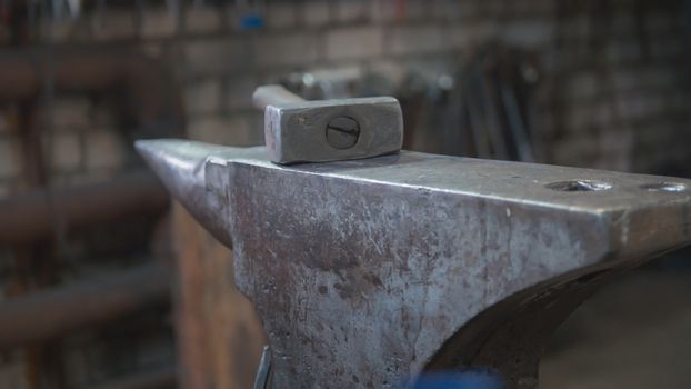 Inside forge workshop - steel vise, hammer and hot furnace, close up