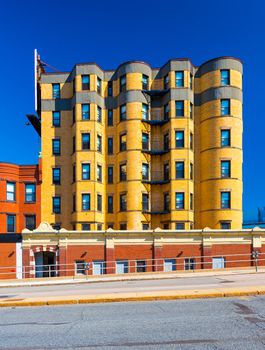 Residential building made of yellow bricks. Apartment block in the street of Boston, Massachusetts, USA. Summer day with clear blue sky.