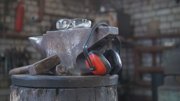 Forge workshop - hammer, anvil and protect headphones, close up