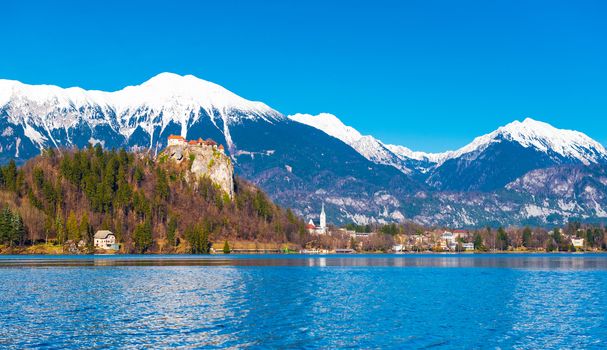 Lake Bled in Slovenia. Snowy mountains with clear blue sky on the background