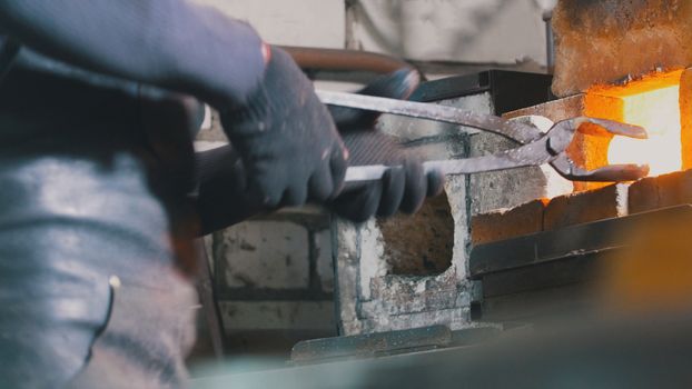 Craftsman blacksmith working with steel in forge , close up