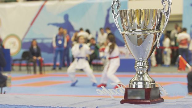 Teenager girls fighting in kimono at all in front of silver cup, close up