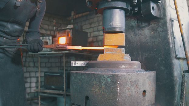 Automatic hammering - blacksmith forging red hot iron on anvil, extreme close-up, telephoto