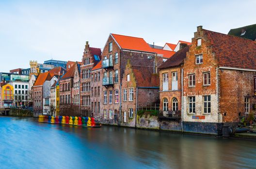 Gent (Ghent) - February 2016, Belgium: Old medieval brick houses in traditional style and water canal in one of the most popular tourist destination of Belgium