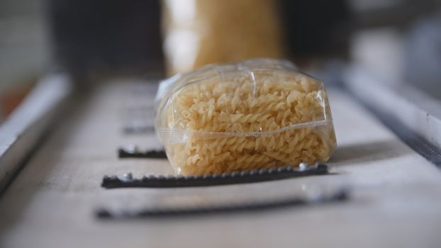 Food industry - conveyor with plastic pack of macaroni, panoranic