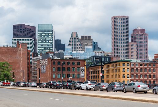 Boston - June 2016, MA, USA: Boston cityscape in a cloudy day, view on skyscrapers and historic old buildings in downtown, cars parked on the bridge above the highway
