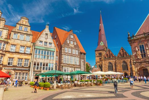 Bremen - July 2018, Germany: View of the Central Square of Bremen with traditional Gothic architecture, cafe, restaurants and walking people. The famous German town, popular tourist destination
