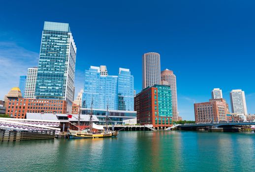 Boston - June 2016, MA, USA: Boston skyline, old historic ship in Tea Party museum and modern buildings in downtown reflected in the water of Boston harbor
