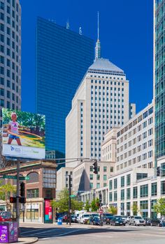 Boston - June 2016, USA: The street of Boston, view of John Hancock Tower, Berkeley Building and surrounding buildings in Back bay district, cars on intersection