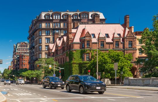 Boston, MA - June 2016, USA: Street view with historical houses made of brown stone and cars moving in Back Bay district of Boston