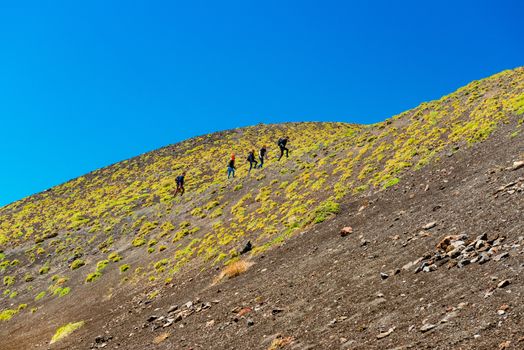 Mount Etna - May 2019, Sicily, Italy: A group of people climbing up to the top of the Mount Etna