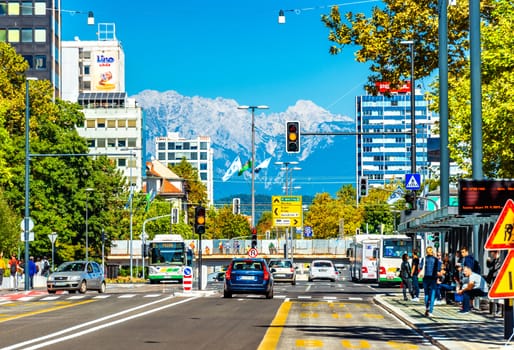 Ljubljana - September 2019, Slovenia: View of the main street with car traffic and beautiful snowy Alps in the background
