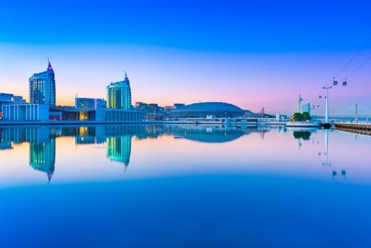 Lisbon - February 2019, Portugal: The Nations Park (Parque das Nações) in the evening. Modern city skyline mirrored in the water