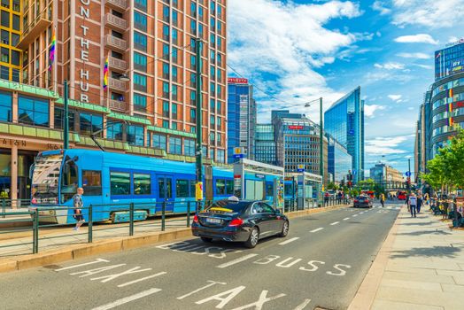 Oslo - June 2019, Norway: A street in the central part of Oslo with modern buildings, tram and taxi car