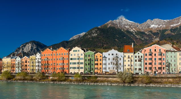Innsbruck - November of 2014, Austria: Сolored houses on the bank of the river Inn, Innsbruck cityscape in sunny day with mountains and clear blue sky