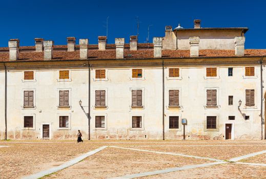 Mantua (Mantova) - July 2017, Italy: Lonely woman walking along The Castle Square (Piazza Castello)in Mantua