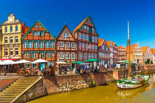Stade - July 2019, Germany: Cityscape of a small, beautiful German town with the traditional half-timbered architecture and canal with an old wooden sailboat