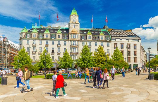 Oslo - June 2019, Norway: View of the Grand Hotel Oslo and people walking around