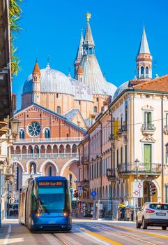 Padova (Padua) - February 2017, Italy: The street of Padua with traffic. Modern tram is moving towards the central square. The Basilica of St. Anthony of Padua (Basilica di Sant'Antonio di Padova)
