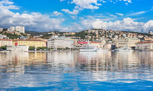 Rijeka - June of 2012, Croatia: View of Rijeka harbor with white ships at the pier, skyline of the city center, sunny day, blue sky with clouds