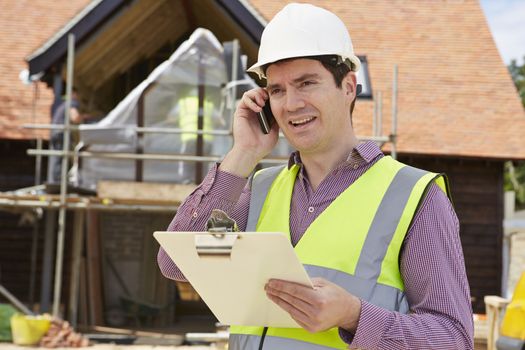 Architect On Building Site Using Mobile Phone