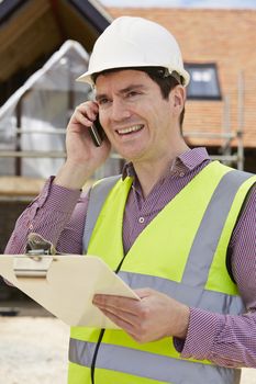 Architect On Building Site Using Mobile Phone