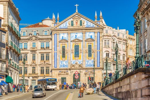 Porto - February 2019, Portugal: View of the Saint Anthony's Church (Igreja de Santo Antonio dos Congregados). A street with car traffic and people walking near Sao Bento station