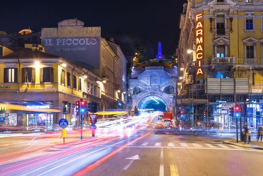 Trieste, Friuli Venezia Giulia region - March 2015, Italy: Night view of the city of Trieste with car traffic lights trails, Pharmacy store and McDonalds building on Piazza Carlo Goldoni.