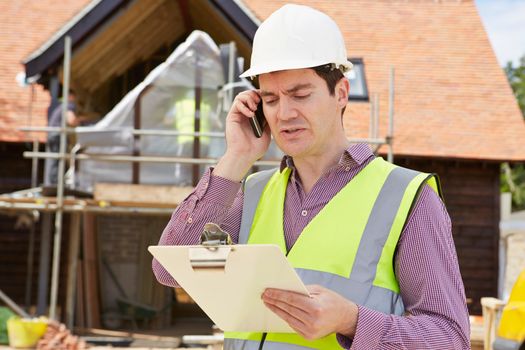 Architect On Building Site Using Mobile Phone