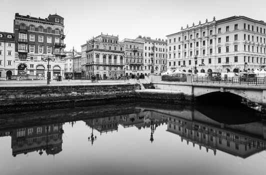 Trieste - December 2016, Italy: Old historical buildings mirror reflected in water, Grand Canal in Trieste city center, black and white cityscape