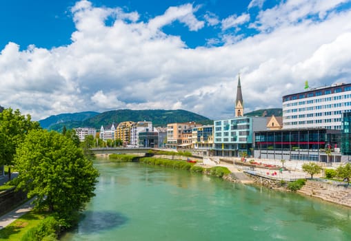 Villach - May 2016, Austria: Cityscape of the small Austrian city of Villach on a sunny day, view of Drava river, historical buildings, hotels and Church in the old city centera