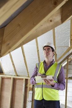 Building Inspector Looking At Roof Of New Property