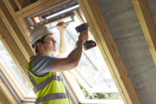 Construction Worker Using Drill To Install Window