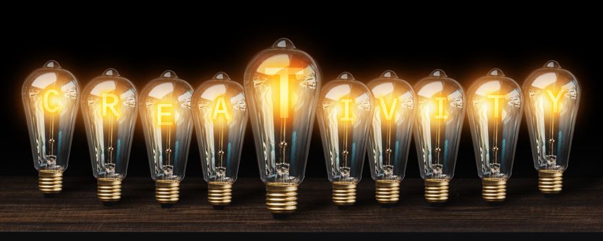 success, strategy and business innovation creativity word idea energy with light bulb on wood table in dark tone, successful creative technology and invention concept