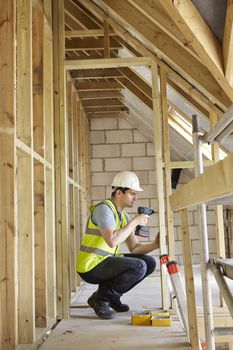 Construction Worker Using Drill On House Build