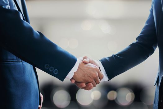 successful contract negotiate and handshake concept, two businessman shake hand with partner to celebration partnership, teamwork, business deal in room meeting after success communication, agreement