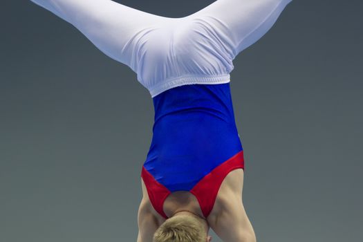 Male gymnasts performing elements at the championship, close up