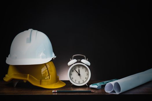 real estate, property and construction project concept, engineer's tools  with helmet on table in dark background 