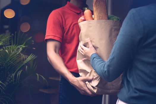 Delivery man send bag of vegetables and food to customers