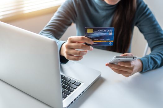 Woman use credit card paying on phone and laptop, e commerce and shopping online concept, Credit card make it up especially for photo stock