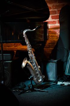 Beautiful saxophone stands on the stand on stage in jazz bar, close up