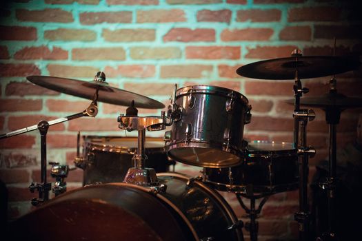 A beautiful drum stands against a brick wall in a jazz bar, close up