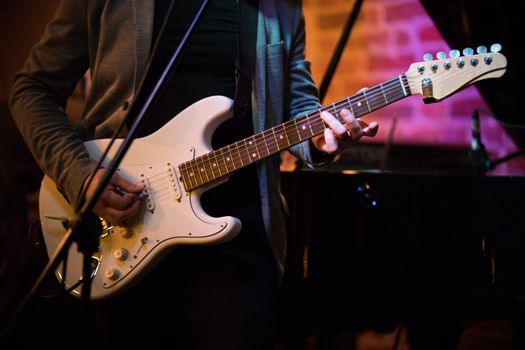 Unknown musician plays guitar at a party in a jazz bar, close up
