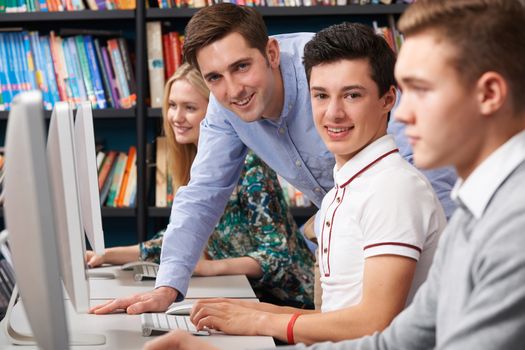 Tutor Helping Teenage Students Wotking At Computers