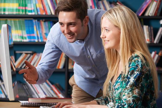 Teacher Working With Teenage Pupil At Computer