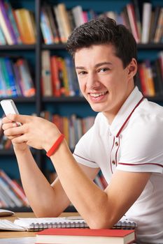 Male Teenage Pupil Texting In Classroom