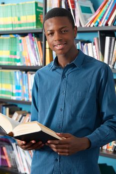 Male Teenage Student Studying In Library