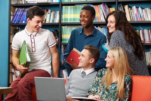 Group Of Teenage Students Working Together In Library