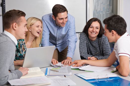 Teacher Working In Classroom With Students