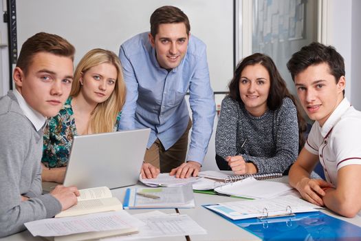 Portrait Of Teacher And Pupils Working In Classroom Together